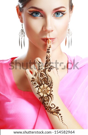 Beautiful girl face with perfect arabian make up with hand with detail of henna being applied to it isolated