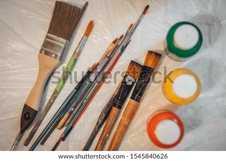 Picture of wooden paintbrush set different size with paint tubes on the table. Top view, homemade artist