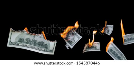 Several 100 dollar bills, falling down, burn on a black background. The concept of bankruptcy, depreciation, devaluation, wastefulness and waste of money. Copy space, isolated. Royalty-Free Stock Photo #1545870446