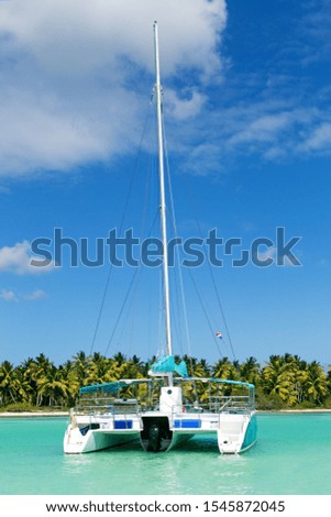 Catamaran sailing in Caribbean sea with palm beach background