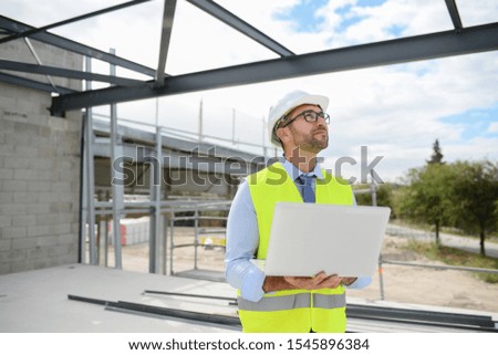portrait of handsome foreman construction worker on a industrial building industry construction site
