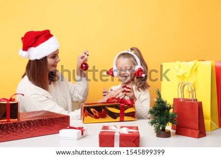 Xmas concept. Mother with girl on holiday. Unpacking gifts together.