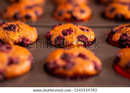 Newly baked nine banana-cherry muffin on a muffin tray