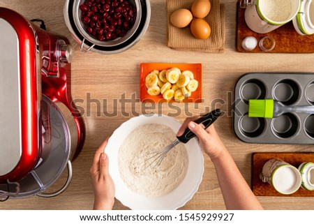 Hand whisked flour, banana slices, cherries and other ingredients for muffin making
