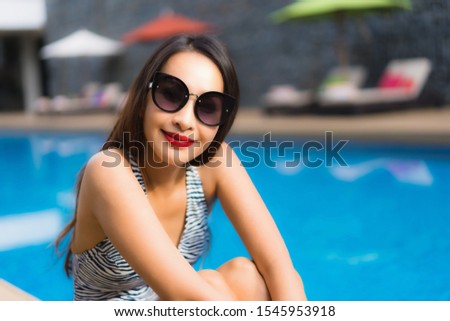 Beautiful portrait asian woman relax happy smile around outdoor swimming pool in holiday vacation