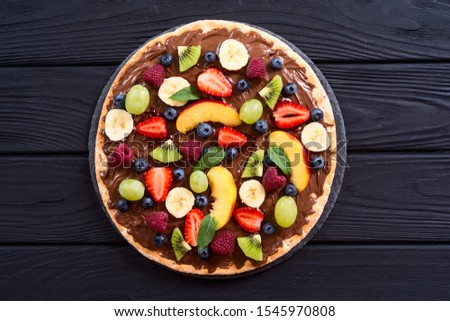 Fruit pizza with nut nougat cream , fruit and berries . Sweet dessert