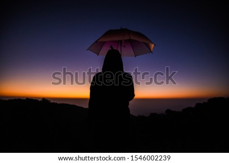 Umbrella, a beautiful woman watching the morning sun rise alone.