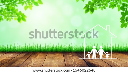 Happy Family Concept : Family and home icons on wooden floor with green natural and sunlight in background.