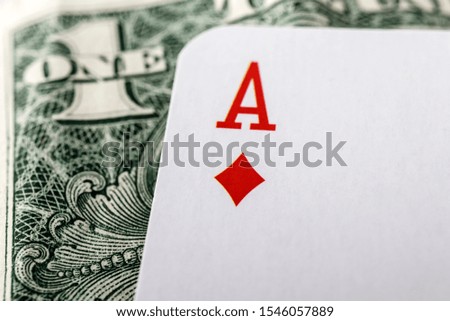 Ace of diamonds, playing card close up lying on top of United States Currency. Gambling, winning concept. Gambling entertainment. Play games of chance for money.