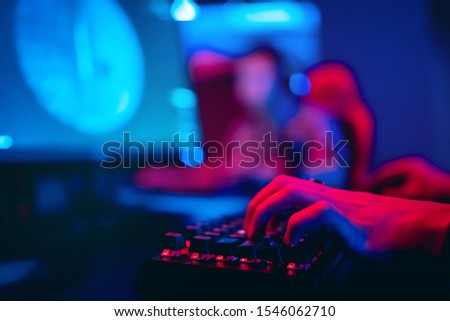 Blurred background computer, keyboard, blue and red lights. Concept eSports arena for gamer playing tournaments.