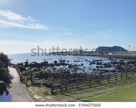 Sea of Jeju Island with a view of a small island in the distance. You can walk along the lawn.