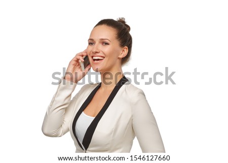 Business woman in a happy mood talking on a smartphone in a white jacket with her hair in a bun