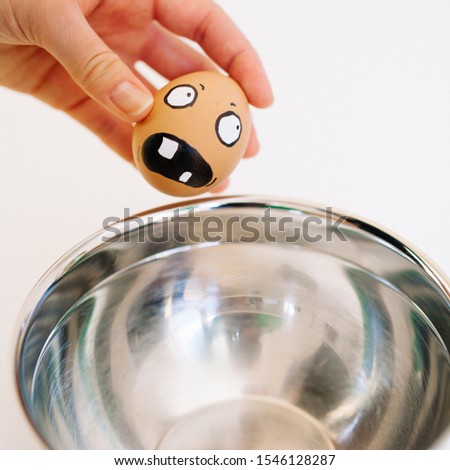 A funny shot of an egg with a depiction of frightened face on it when put into a bowl with hot water
