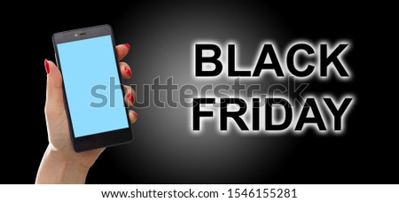 Hand holding cellphone with black friday text and shopping cart