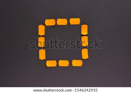 Price tags and stickers are orange in the form of a square sign on a dark gray paper background.