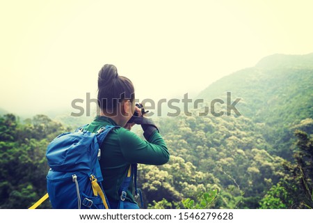 Woman photographer taking photo on spring forest mountain