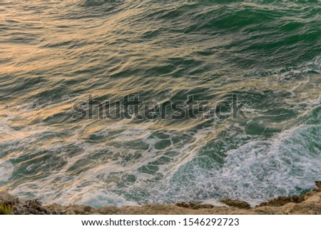 Rocks, waves and Surf on the coast and beach. Beautiful blue open wavy ocean in summer time. Sea at sunset. Rocks, waves and Surf on the coast and beach.