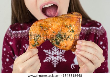 Cropped closeup photo portrait of satisfied excited cheerful teen child enjoying junk unhealthy fast food in hands isolated grey background wearing burgundy x-mas jumper