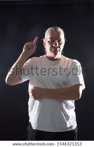 Mature older man in studio. Anger and upset, annoyed. low key on black background