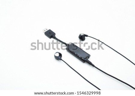 Black ear buds connected to external sound card isolated on white background