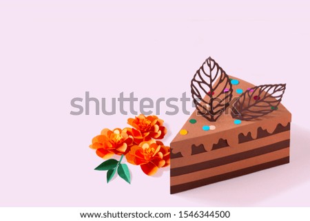 Piece of paper chocolate cake and flowers. Cake is decorated with paper chocolate leaves. Volumetric handmade paper objects. Paper art and craft. Trendy hobby. Minimal art food concept. Copy space
