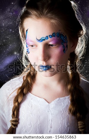 Pretty girl with face painting of sign of the zodiac Scorpio