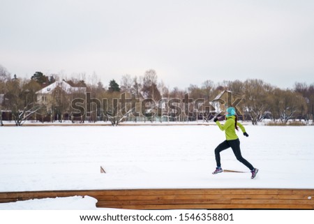 Photo of young athlete running in winter park