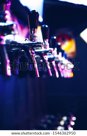 A row of beer steel taps in the pub. The cranes are intended for bottling beer beverage.