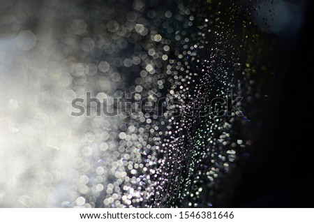 many size of Bokeh, glitter light on black background, reflect from rain drop on window 