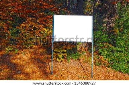 A blank white board for information in autumn forest