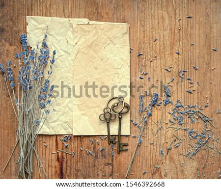 lavender flowers, bronze vintage keys and old paper on rustic wooden background. composition in retro romantic nostalgic style. top view. copy space. template for design