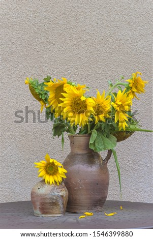 Bunch of sunflowers in the old clay jug. Vertical picture