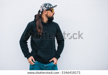 City portrait of handsome hipster man with beard wearing black blank hoodie or hoody with space for your logo or design. Mockup for print
