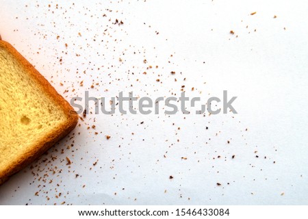 Top or above view of Sliced toast bread for breakfast with brown Breadcrumbs scattering on white table background in kitchen light, healthy homemade food & cooking class review concept, copy space  Royalty-Free Stock Photo #1546433084