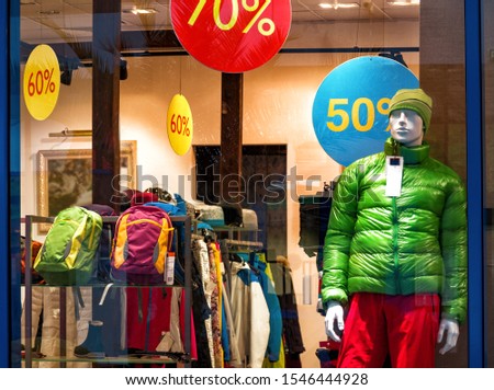 Shop window with store background. Fashion collection of winter or autumn sport clothes on mannequin and discount signs