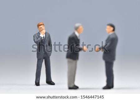 Miniature people business man are standing with each other and shaking hands