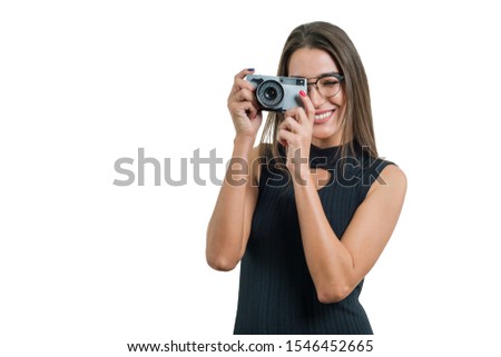 Portrait of young beautiful woman photographer in glasses black dress with retro photo camera, isolated on white background