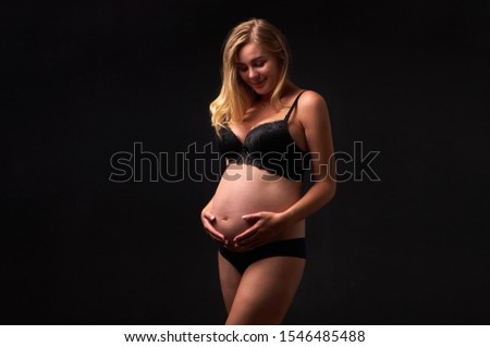 beautiful pregnant woman holds belly with hands