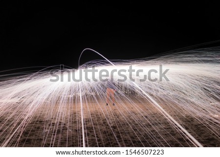 Steel wool night photography throwing circular flames. Spinning burning steel wool