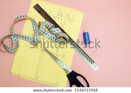 Seamstress tools. Threads, scissors, pattern and ruler for sewing. The concept of cutting and sewing. Female needlework. Atelier and clothing modeling.