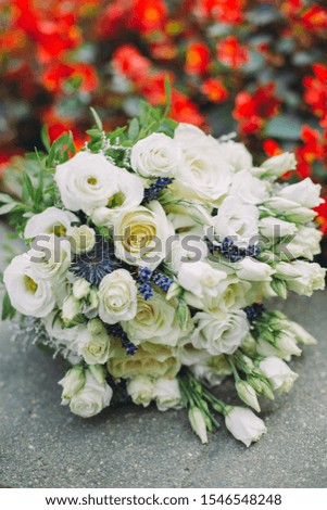 wedding bouquet with white roses near red flowers