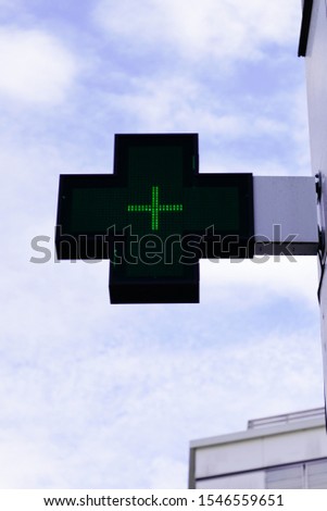 green cross above a pharmacy