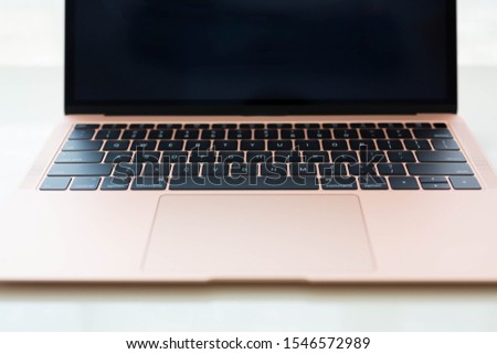 Top view of rose gold laptop on white background