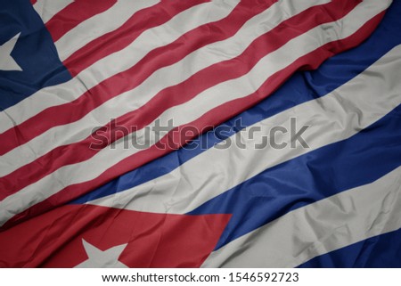 waving colorful flag of cuba and national flag of liberia. macro