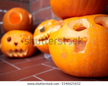 Five pumpkins carved for Halloween on a front door step in England ready for Trick or Treat door knockers