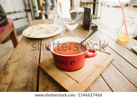 Red soup served on a wooden board