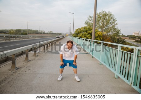 Tired athlete after running on the bridge