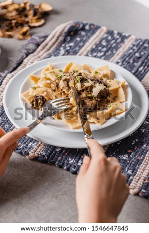 
Plate with delicious homemade pasta with mushroom sauce on a rustic napkin. Close-up.