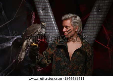 falconer holding Sea Eagle on glove. man in a military uniform with a fighting large bird of prey on his arm