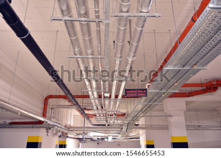 Sanitary system pipes and electrical cables installed under flat slab reinforced concrete structure in building.  